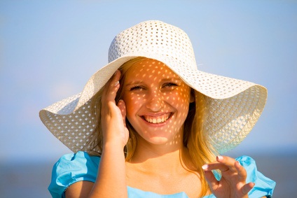.Young girl under hat in summer